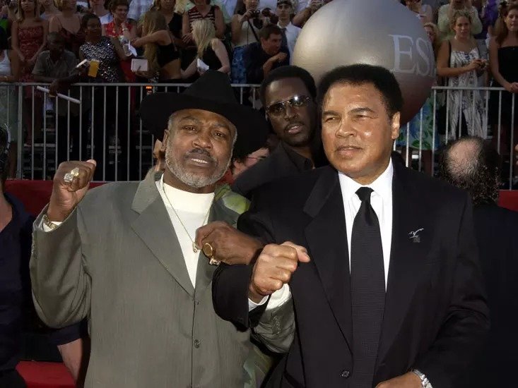 JOE FRAZIER AND MUHAMMAD ALI POSE FOR A PHOTO IN 2002, 27 YEARS AFTER THEIR LAST FIGHT