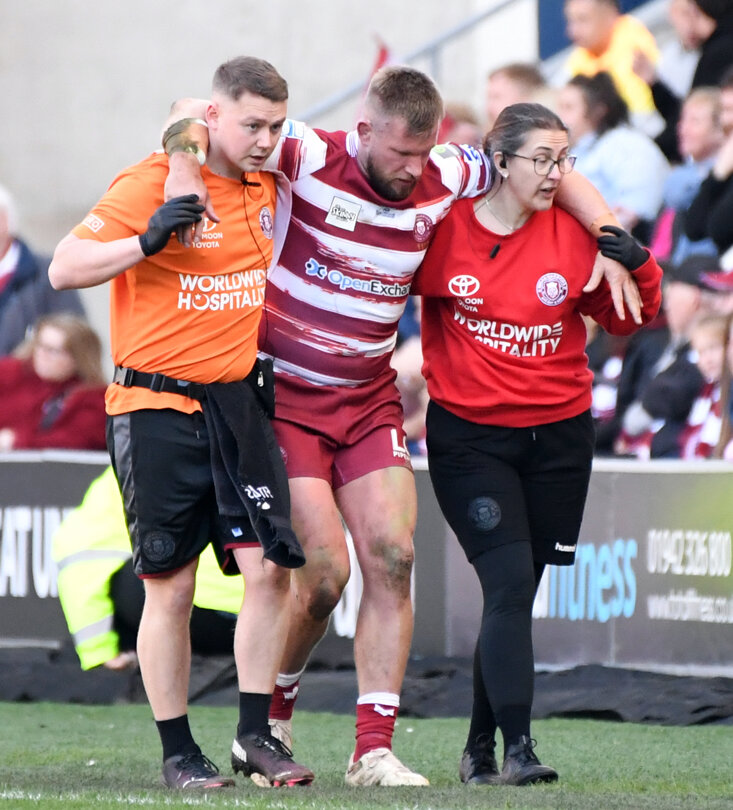 Wigan Warriors' Mike Cooper is helped off the field